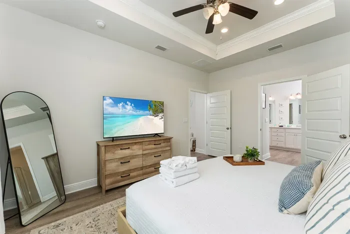 Unwind in the cozy master bedroom featuring a 55” smart TV for your favorite shows and a full-length mirror to get beach-day ready. A perfect space to relax and recharge after a day in the sun.