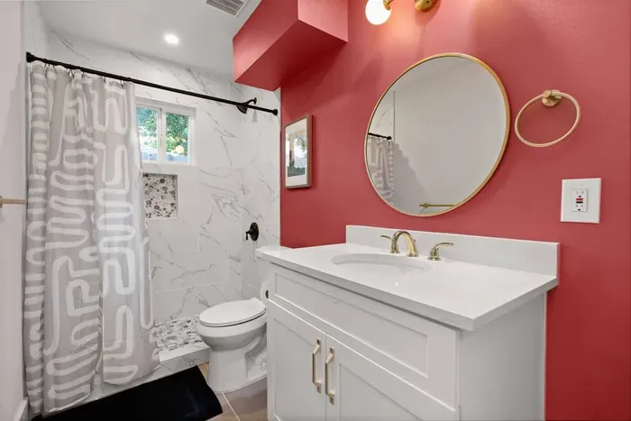 Full primary bathroom stocked with fresh towels, shampoo, conditioner, body wash, and blow dryer