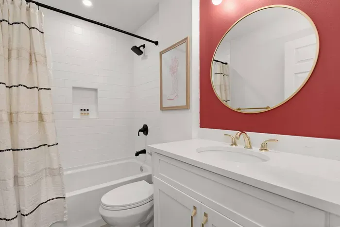 Full hallway bathroom stocked with fresh towels, shampoo, conditioner, body wash, and blow dryer