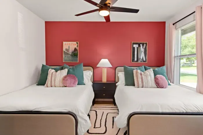 Double bedroom with two full-sized beds, Roku TV, dresser, ceiling fan, and full length mirror