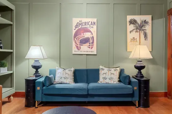 - A cozy corner to unwind—enjoy a drink or conversation by the original fireplace, complete with a bold gray mantel that complements the room’s classic features.