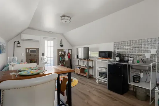 A cozy open-concept living area with a fully equipped kitchenette, complete with a mini-fridge, microwave, and all the essentials.