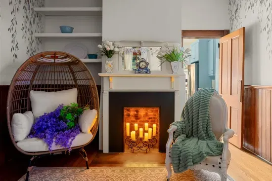 The glowing fireplace and rattan egg chair create a cozy nook in the Ladies’ Room, ideal for curling up with a soft throw and a warm drink.