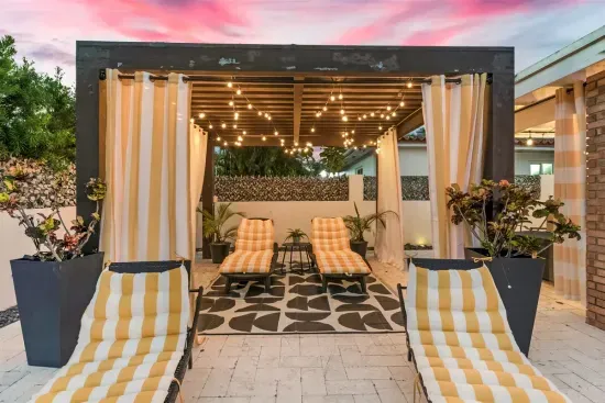 Relax under twinkling lights with chic loungers and vibrant decor in Miami!
