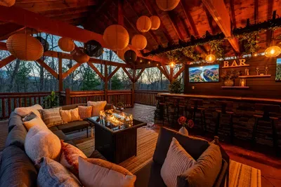 Custom outdoor bar with seating for 12, three wall mounted TV’s, and a cozy seating area with fire table.