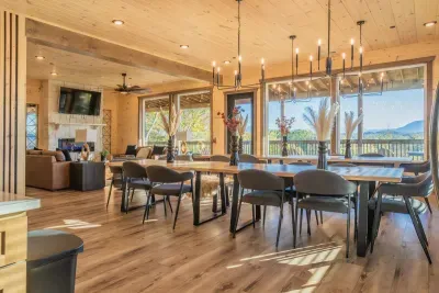 Spacious and inviting: enjoy meals together at two large dining tables with a perfect view of the TV and cozy fireplace.