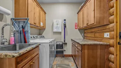 Spacious laundry room with washer, dryer, large washing sink and organizing counter.