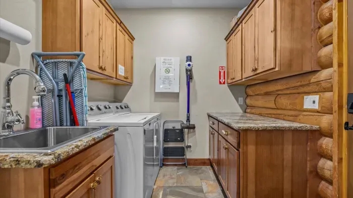 Spacious laundry room with washer, dryer, large washing sink and organizing counter.