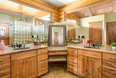 Main floor ensuite bathroom with a hair and make up vanity, 2 sink areas, and an extra large shower with two shower heads.