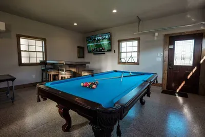 The garage not only includes arcade machines, but also a bar area with a giant 75" 4k TV!