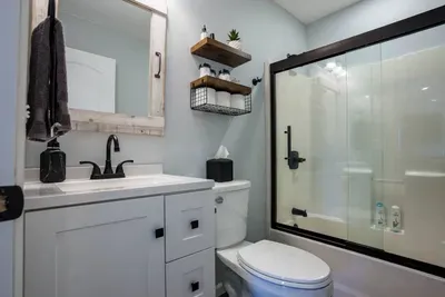 This bathroom includes a full sized tub and shower.