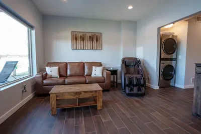 The downstairs living room includes a massage chair, pull-out sleeper couch, laundry, and 65" 4k TV.