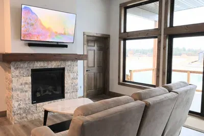 A peaceful living room with a view of the lake with direct access to the deck. (UPSTAIRS)

Simply flip a switch to turn on this cozy gas fireplace!