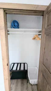 Each bedroom is equipped with a suitcase rest, a laundry basket, hangers, and a small fan.