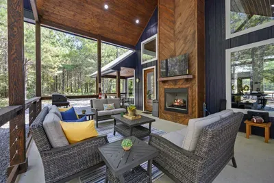 Covered outdoor porch with a fireplace and smart TV