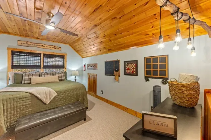 Relax in this peacefulloft bedroom featuring warm wood ceilings and comforting textures