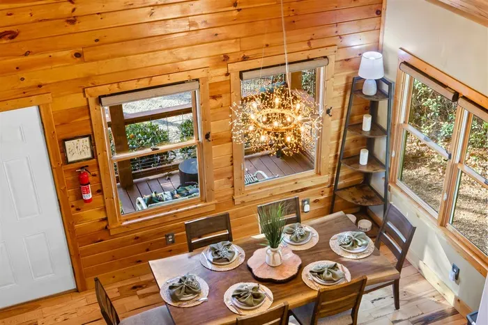 Bright dining space surrounded by windows — enjoy morning coffee with a forest view