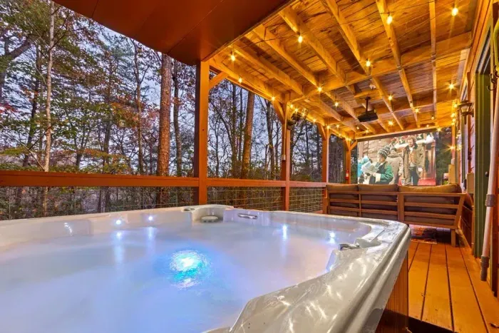 Unwind in the hot tub and enjoy outdoor movie nights on the covered porch at our Helen, GA cabin.