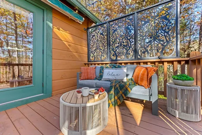 Private balcony with decorative privacy panel — morning fresh-air lounging with forest views