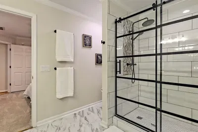 Step into luxury in this stylish Jack & Jill bathroom featuring a sleek, black-framed glass shower with modern tile accents & a rainfall showerhead. With easy access from the adjoining bedrooms, this space is thoughtfully designed for convenience & comfort