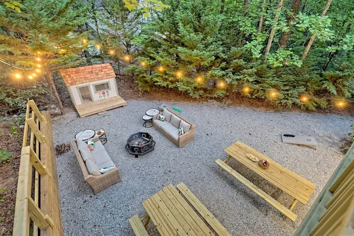 Private backyard with fire pit, lounge seating, and kids’ playhouse String lights, picnic tables, and space to relax or play outdoors.