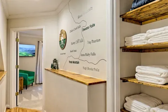 "Discover the best local hiking spots with our custom trail map, featuring popular destinations like Desoto Falls, Anna Ruby Falls, and Yonah Mountain. Conveniently located in the hallway, it's your guide to exploring nature during your stay."