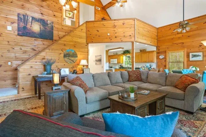 Comfortable seating, wood-beamed ceilings, and a stone fireplace create a warm mountain atmosphere.