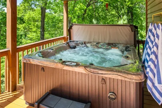 Private hot tub on a separate covered porch — soak under the stars with mountain air all around you.