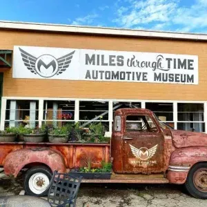 The vintage truck display and main storefront signage at Miles Through Time Automotive Museum in Clarkesville, Georgia.