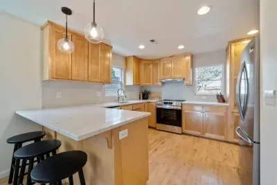 Clean and fully stocked kitchen with brand new quartz countertops. Beautiful sunlight in this space.