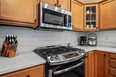 Fully-stocked kitchen with new quartz countertops and bar seating for 4