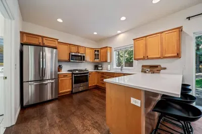 Fully-stocked kitchen with new quartz countertops and bar seating for 4
