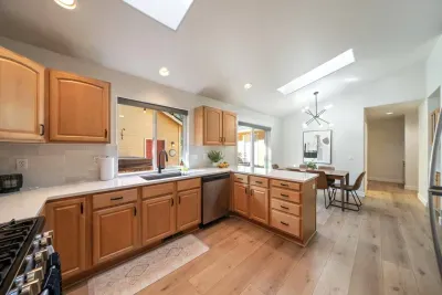 Fully-stocked and beautifully updated kitchen with stainless steel appliances has an open concept layout and views to the back deck.
