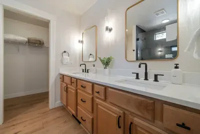 Private primary ensuite bathroom has double sinks in large vanity across from large walk-in shower. Leads to spacious walk-in closet with 2 extra rollaway twin beds for the 7th or 8th person (best for children or small adults).