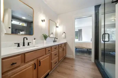 Private primary ensuite bathroom has double sinks in large vanity across from large walk-in shower. Leads to spacious walk-in closet with 2 extra rollaway twin beds for the 7th or 8th person (best for children or small adults).