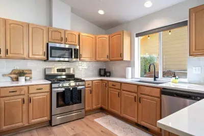 Fully-stocked and beautifully updated kitchen with stainless steel appliances has an open concept layout and views to the back deck.