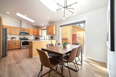 Dining room with comfortable, easily wipeable seating with modern sputnik chandelier and books and board games in the cabinet nearby