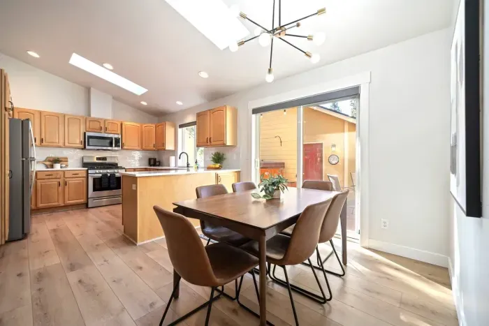 Dining room with comfortable, easily wipeable seating with modern sputnik chandelier and books and board games in the cabinet nearby