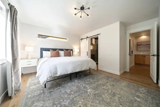 Massive primary suite with king bed, dedicated office space, private door to back deck, and beautiful sliding barndoor to the primary ensuite bathroom. There are an additional 2 rollaway twin beds (best for small adult or child) stored in the closet.
