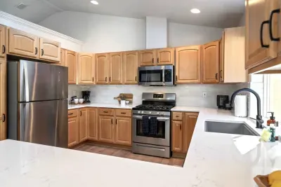 Fully-stocked and beautifully updated kitchen with stainless steel appliances has an open concept layout and views to the back deck.