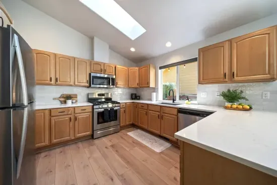 Fully-stocked and beautifully updated kitchen with stainless steel appliances has an open concept layout and views to the back deck.