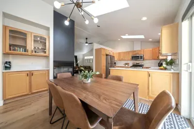 Dining room with comfortable, easily wipeable seating with modern sputnik chandelier and books and board games in the cabinet nearby