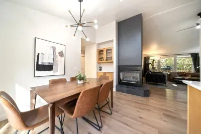 Dining room with comfortable, easily wipeable seating with modern sputnik chandelier and books and board games in the cabinet nearby