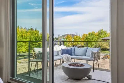 Private balcony with cozy lounge seating, fire pit, and scenic treetop views