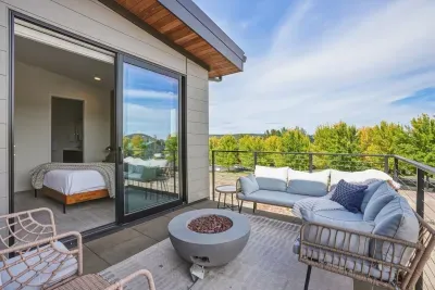 Private balcony with cozy lounge seating, fire pit, and serene treetop views