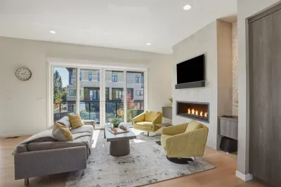 Bright modern lounge with fireplace, TV, and sunny balcony views