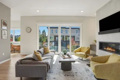 Bright modern lounge with fireplace, TV, and sunlit balcony views
