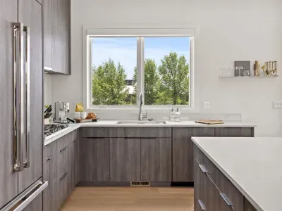 Bright designer kitchen with quartz counters and a scenic window view