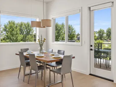 Sun-filled dining space with patio access and peaceful tree views