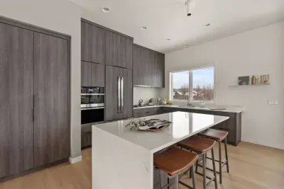 There is seating for 3 atop leather designer stools, and even more room to gather around the waterfall countertop edge for special moments!